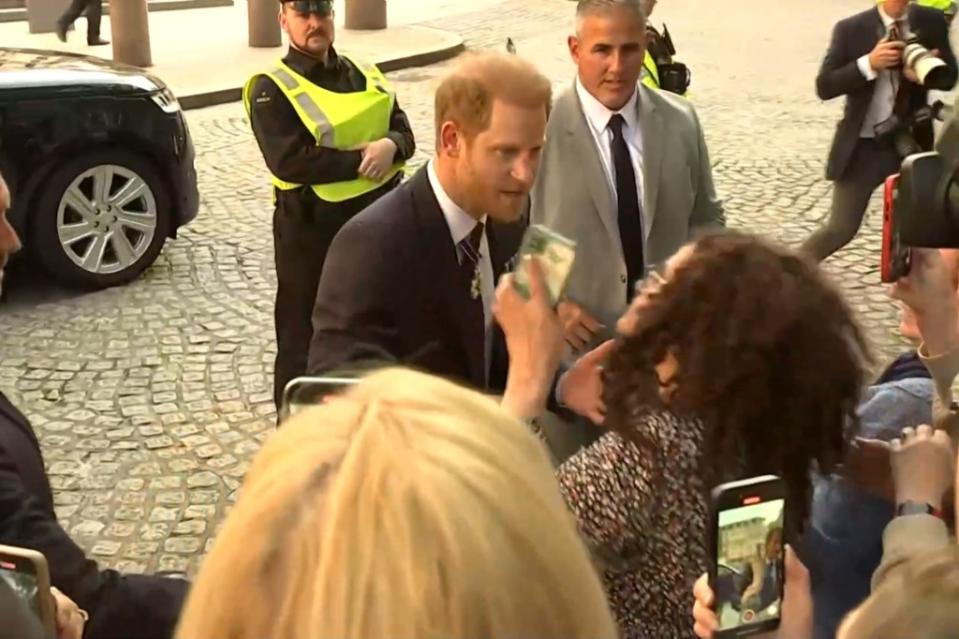 Prince Harry (center) got annoyed with a woman using two phones to photograph him. Reuters