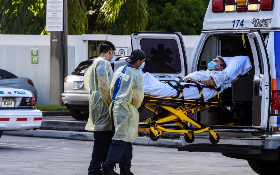 Medics transfer a patient on a stretcher from an ambulance outside of Emergency at Coral Gables Hospital where Coronavirus patients are treated in Coral Gables near Miami, on July 30, 2020. - Florida has emerged as a major new epicenter of the US battle against the disease, with confirmed cases recently surpassing New York and now second only to California. The state toll has leapt over the past week and more than 6,500 people have died from the disease there, according to health officials. More than 460,000 people have been infected with the virus in Florida,  - AFP