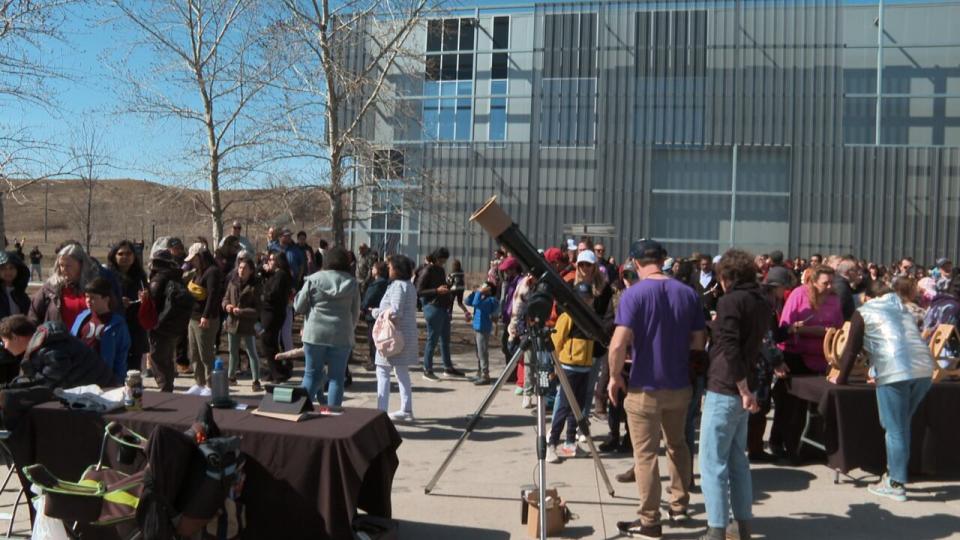 People gathered outside the Telus Spark Science Center to take in the solar eclipse in Calgary. 