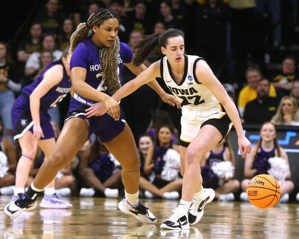 Iowa's Caitlin Clark dribbles as Holy Cross' Simone Foreman defends during Saturday's NCAA Tournament game.