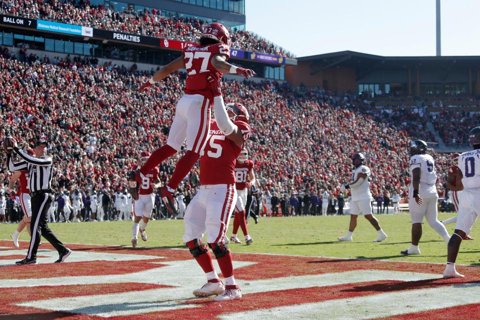 Oklahoma Sooners running back Gavin Sawchuk (27) celebrates with offensive lineman Walter Rouse (75) after a touchdown during a college football game between the University of Oklahoma Sooners (OU) and the TCU Horned Frogs at Gaylord Family-Oklahoma Memorial Stadium in Norman, Okla., Friday, Nov. 24, 2023. Oklahoma won 69-45.