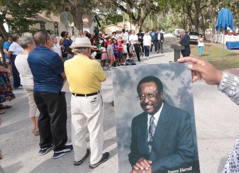 A man holds a portrait of Jimmy Harrell during a ceremony renaming Duss Street as Honorary Jimmy Harrell Way, Thursday, April 27, 2023, in New Smyrna Beach.