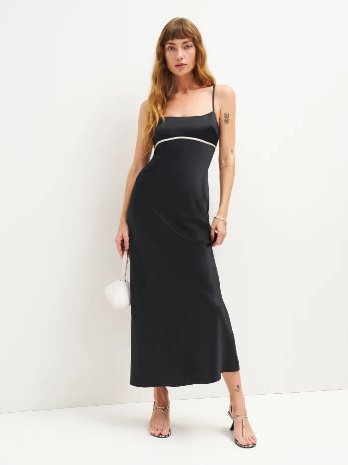 woman wears reformation black Kailyn Silk Dress.