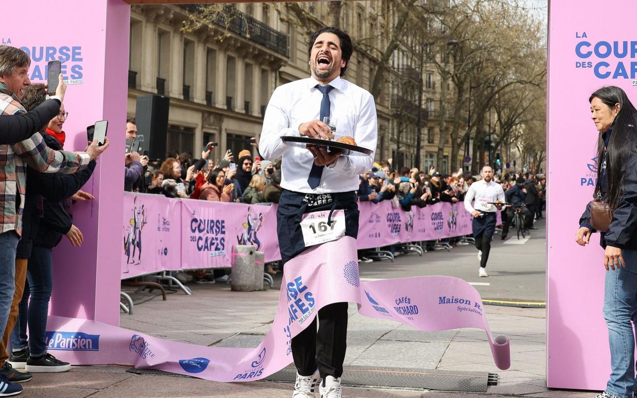 A jubilant competitor crosses the finishing line in the tray race in Paris