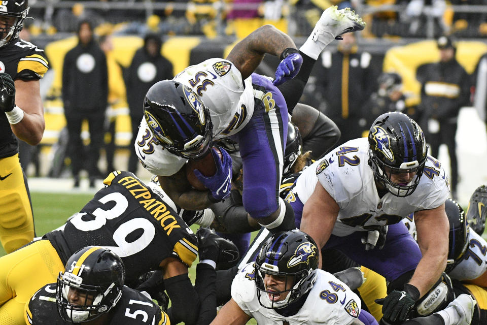 Baltimore Ravens running back Gus Edwards leaps over the pile during the second half of an NFL football game against the Pittsburgh Steelers in Pittsburgh, Sunday, Dec. 11, 2022. The Ravens won 16-14. (AP Photo/Don Wright)
