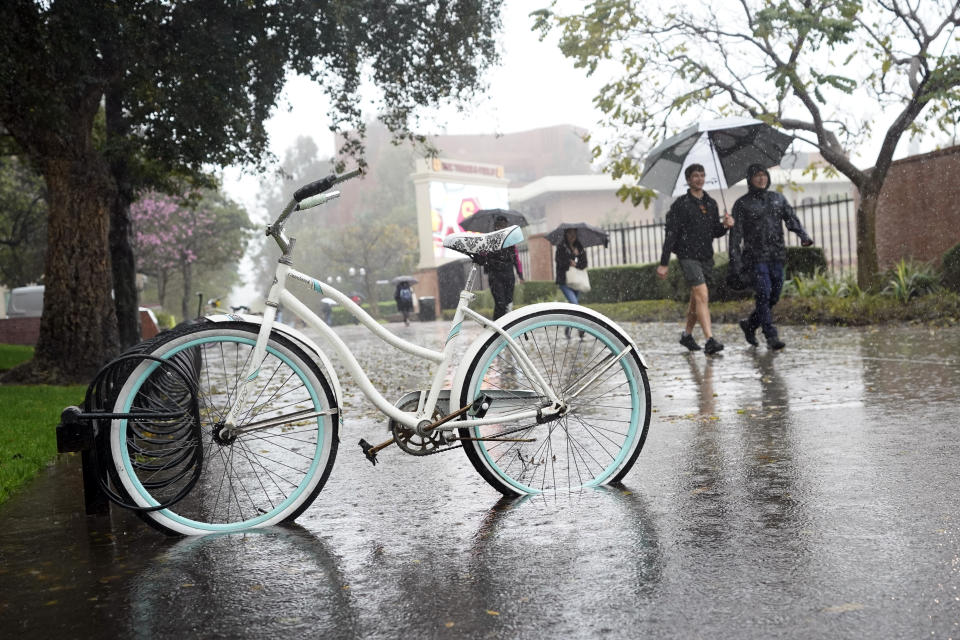 Rain falls on pedestrians on the University of Southern California campus on Tuesday, March 21, 2023, in Los Angeles. (AP Photo/Marcio Jose Sanchez)