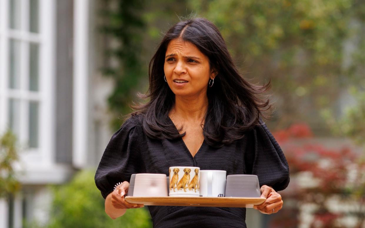 Sunak's wife, Akshata Murty, carrying a tray of tea to journalists outside their family home