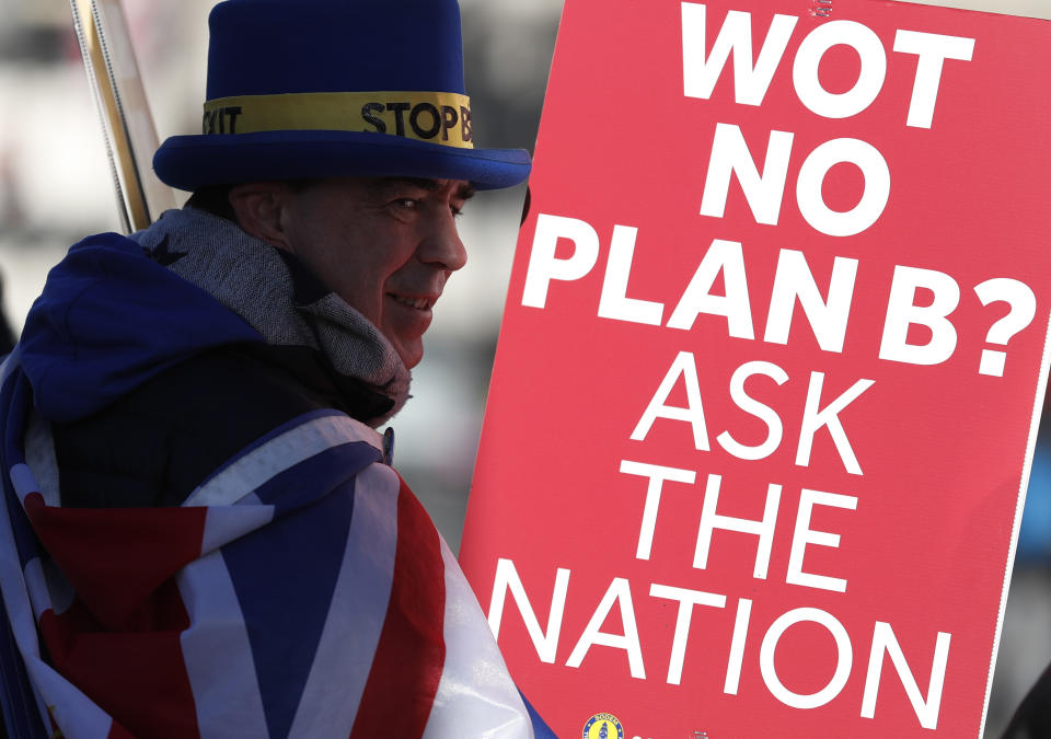 Anti Brexit protester Steve Bray who is almost permanently demonstrating outside the Houses of Parliament watches the traffic as he holds up placards in London, Monday, Jan. 28, 2019. British Prime Minister Theresa May faces another bruising week in Parliament as lawmakers plan to challenge her minority Conservative government for control of Brexit policy. (AP Photo/Alastair Grant)