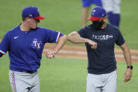 Texas Rangers pitches Kolby Allard, left, bumps elbows with manager Chris Woodward after he was done throwing in an intrasquad game during baseball practice in Arlington, Texas, Monday, July 6, 2020. (AP Photo/Tony Gutierrez)