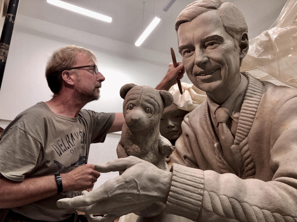 In this undated photo provided by Rollins College, British artist Paul Day, known for his public monuments, works on a sculpture of Fred McFeely Rogers, better known as Mister Rogers, in a foundry in the Czech Republic. (Tomas Hruza/Rollins College via AP)