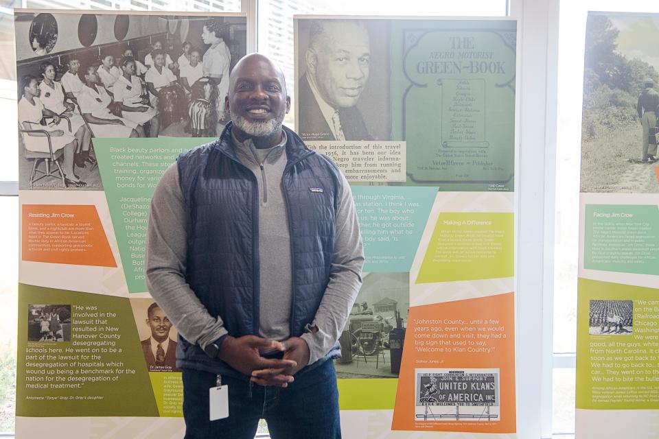 D. Tyrell McGirt, Director of Asheville Parks and Recreation, stands next to the Green Book exhibit at the Dr. Wesley Grant Sr. Southside Community Center, November 15, 2023.