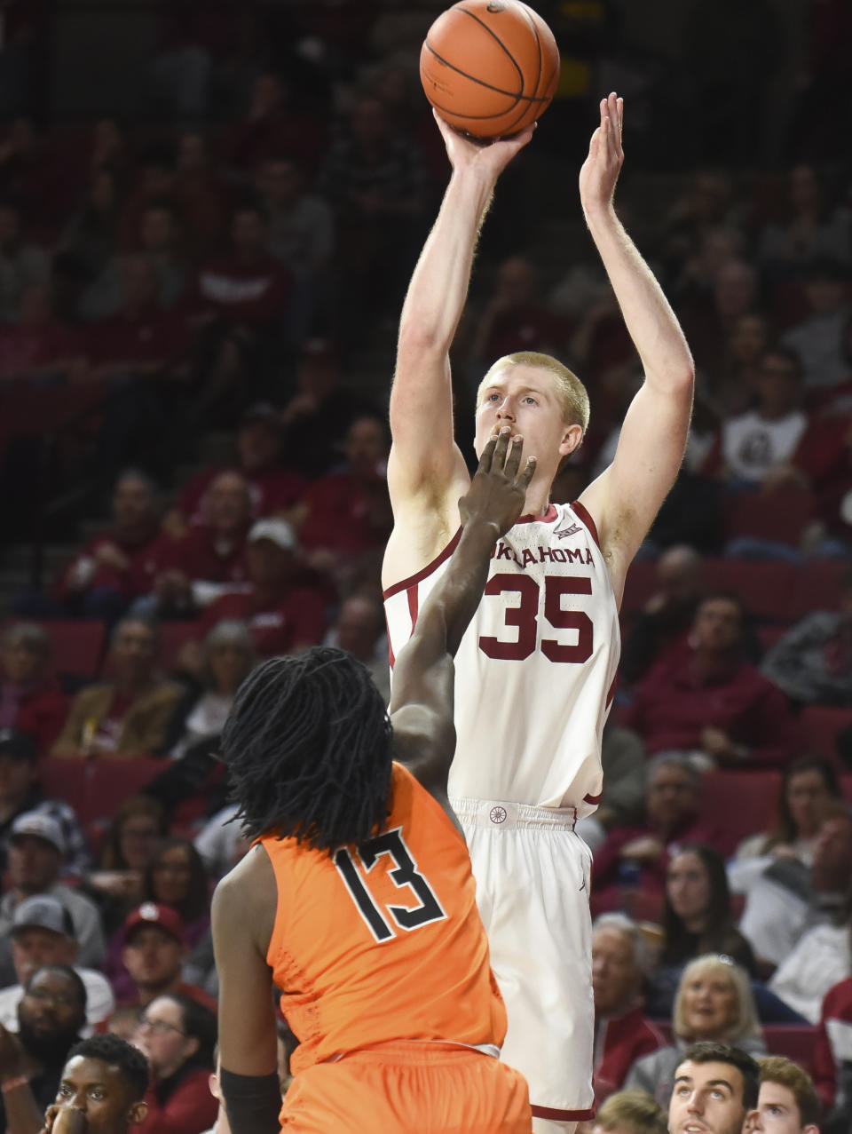 Oklahoma forward Brady Manek (35) shoots the ball over Oklahoma St guard Isaac Likekele (13) during the second half of an NCAA college basketball game in Norman, Okla., Saturday, Feb. 1, 2020. (AP Photo/Kyle Phillips)