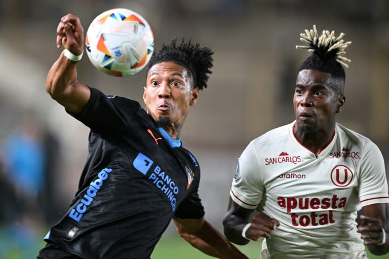 José Quintero (I), de Liga de Quito, y Segundo Portocarrero, de Universitario, disputan la pelota durante un partido de la Copa Libertadores jugado el 2 de abril de 2024 en Lima (ERNESTO BENAVIDES)