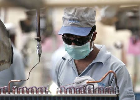 A worker assembles an air conditioner inside the Daikin Industries Ltd. plant at Neemrana in the desert Indian state of Rajasthan, October 1, 2014. REUTERS/Adnan Abidi