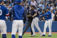 Boston Red Sox third baseman Rafael Devers (11) is held back by an umpire during a heated exchange after Toronto Blue Jays' Alejandro Kirk was hit by a pitch during the fourth inning of a baseball game Wednesday, June 29, 2022, in Toronto. (Christopher Katsarov/The Canadian Press via AP)