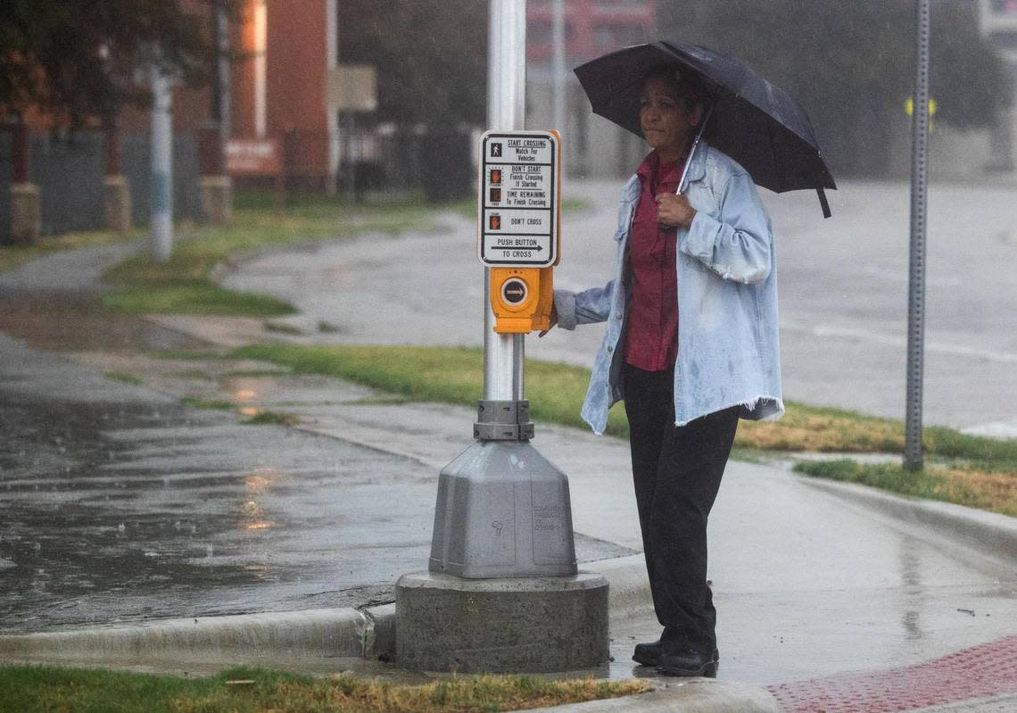 A person waits to cross the road on Jennings Avenue during a heavy rainstorm Monday, Aug. 22, 2022, in Fort Worth.