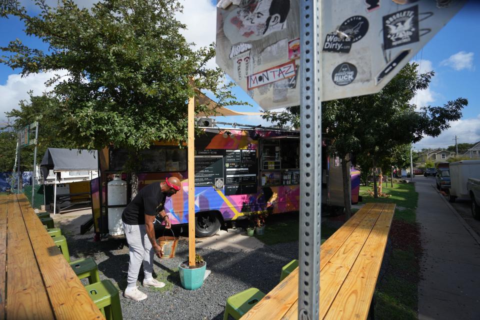 Marlon Rison waters the plants outside of his Community Vegan food truck in September.