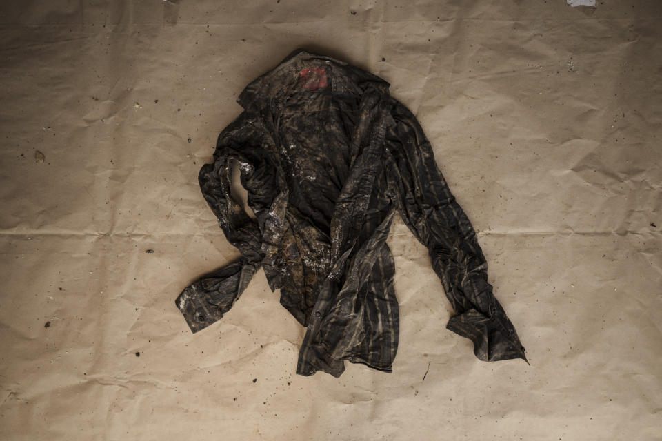 A button-down shirt found on a deceased migrant, whose remains were recovered from a Mauritanian boat on May 28, 2021, is laid out at the Scarborough police station on the island of Tobago, Trinidad and Tobago, Friday, Jan. 21, 2022. May Sow, in France, recognized the black striped button-down shirt. She went back to photos of her nephew, Alassane Sow, from shortly before he disappeared. There it was — the same black striped shirt. He wore it on special occasions. (AP Photo/Felipe Dana)