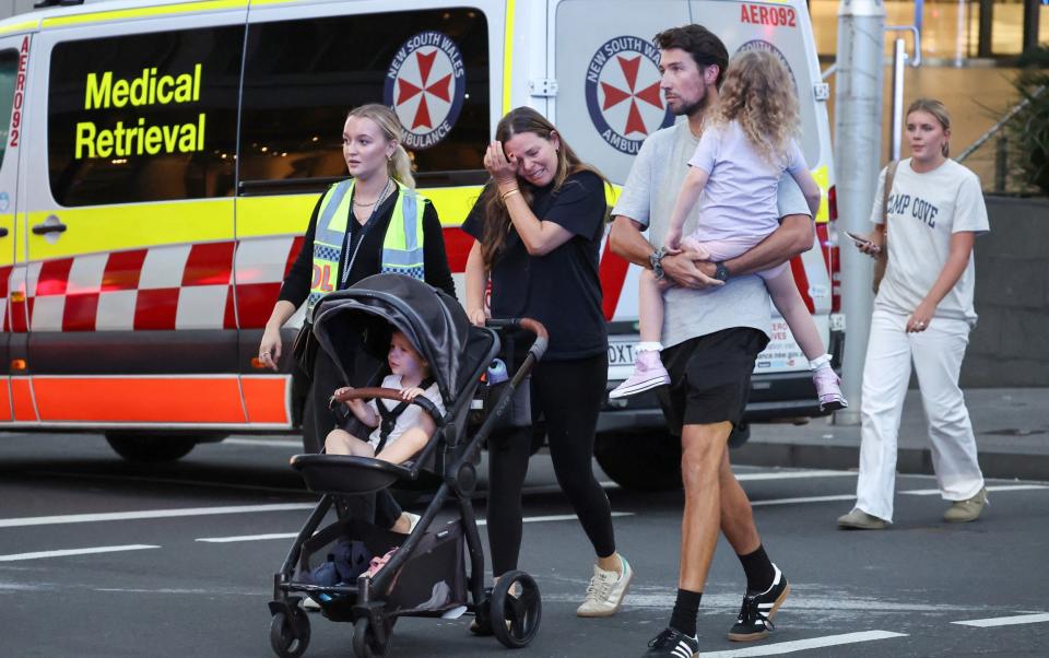 A woman cries as she comes out of the Westfield Bondi Junction shopping mall