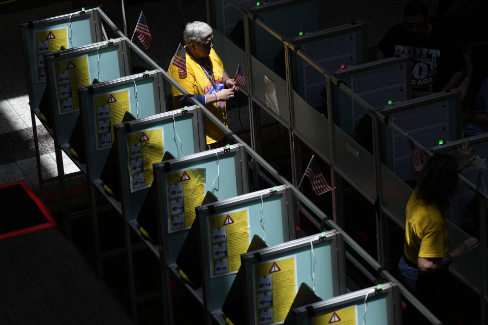 Poll workers help people vote in the Nevada primary at a polling place, Tuesday, June 11, 2024, in Henderson, Nev. (AP Photo/John Locher)