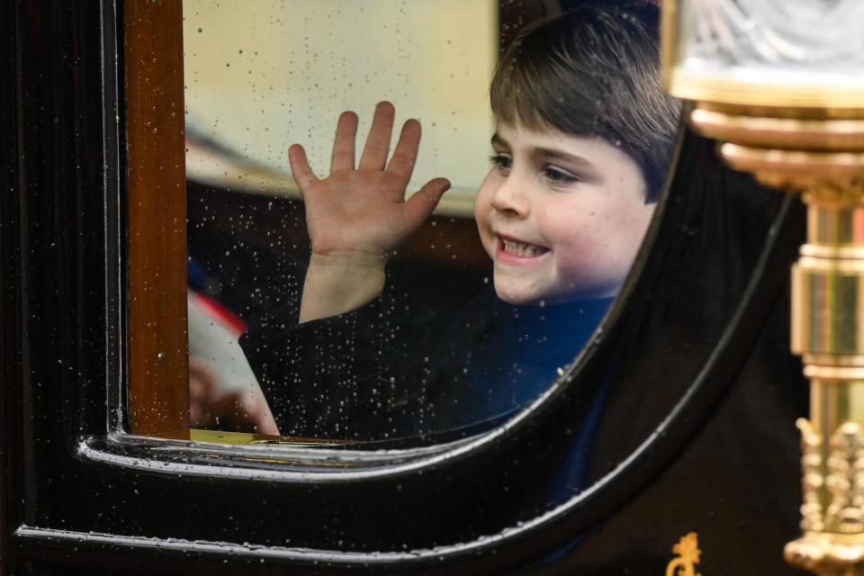 Britain's Prince Louis of Wales smiles through the window as he travels with his family back to Buckingham Palace from Westminster Abbey in central London on May 6, 2023, after the coronations of Britain's King Charles III and Britain's Queen Camilla. - The set-piece coronation is the first in Britain in 70 years, and only the second in history to be televised. Charles will be the 40th reigning monarch to be crowned at the central London church since King William I in 1066. (Photo by Daniel LEAL / AFP) (Photo by DANIEL LEAL/AFP via Getty Images)