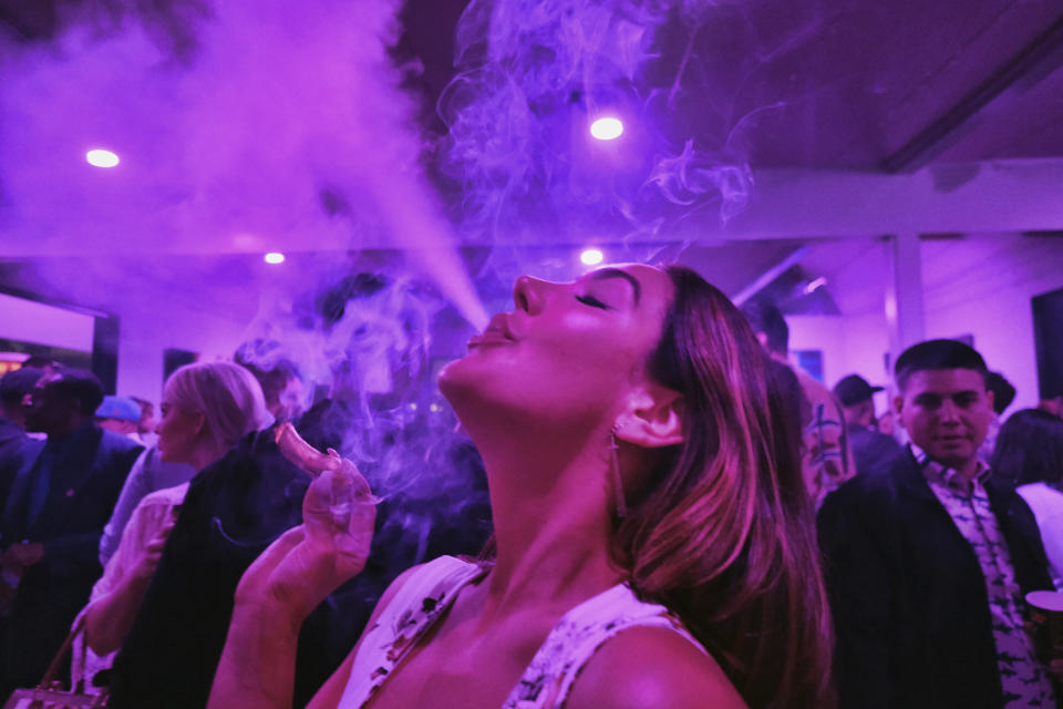 FILE - A guest takes a puff from a marijuana cigarette at the Sensi Magazine party celebrating the 420 holiday in the Bel Air section of Los Angeles on April 20, 2019. Big cannabis companies are backing a new, celebrity-studded campaign to legalize marijuana nationwide, hoping to build pressure on Congress from constituents who haven't always made themselves heard: marijuana users. (AP Photo/Richard Vogel, File)