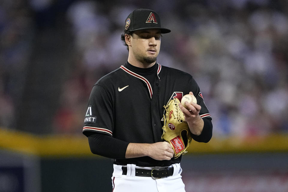 Arizona Diamondbacks relief pitcher Kyle Nelson looks at the ball after walking the bases loaded during the fourth inning of a baseball game against the Boston Red Sox, Saturday, May 27, 2023, in Phoenix. (AP Photo/Matt York)