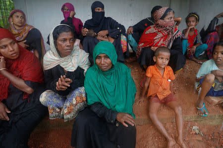 Rohingya refugees take shelter from the rain near their camp in Cox's Bazar, Bangladesh, October 3, 2017. REUTERS/Damir Sagolj