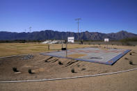 The Estrella Mountains backdrop the grounds of the Gila Crossing Community School, Friday, Jan. 20, 2023, at the in Laveen, Ariz. The school on the Gila River Indian Reservation was hosting a "Road to Healing" event, part of a year-long tour across the country to provide Indigenous survivors of the federal Indian boarding school system and their descendants an opportunity to share their experiences. (AP Photo/Matt York)