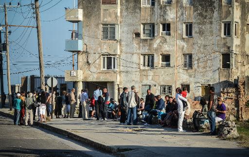 Ciudadanos cubanos hacen fila frente a la oficina de la Sección de Intereses de EEUU (SINA, en inglés), en La Habana, el 11 de marzo de 2013, en procura de conseguir una visa para viajar a Estados Unidos, luego de años de prohibición a dejar el país. (AFP | Adalberto Roque)