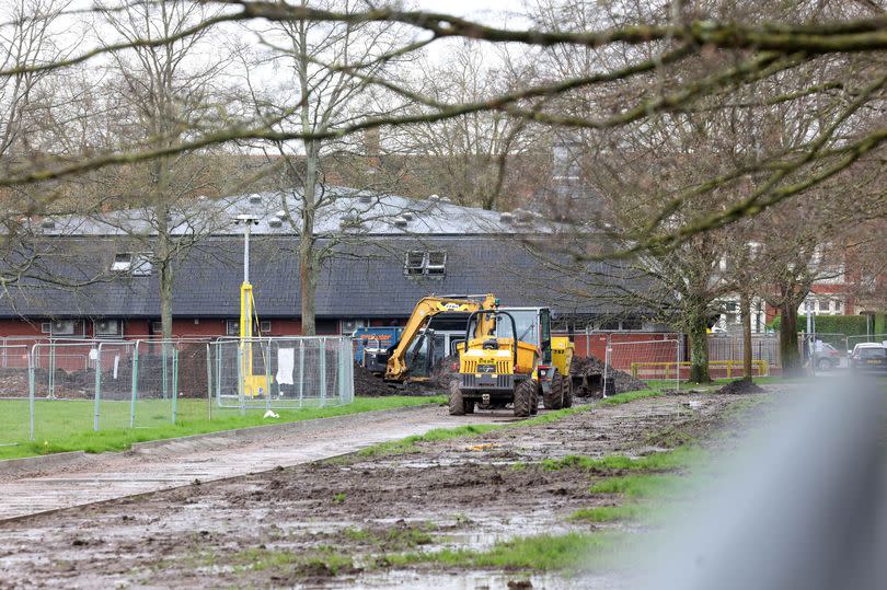 Diggers excavating part of Roath Recreation Ground in Cardiff, having dug a trench filled with the beginnings of the cycle lane