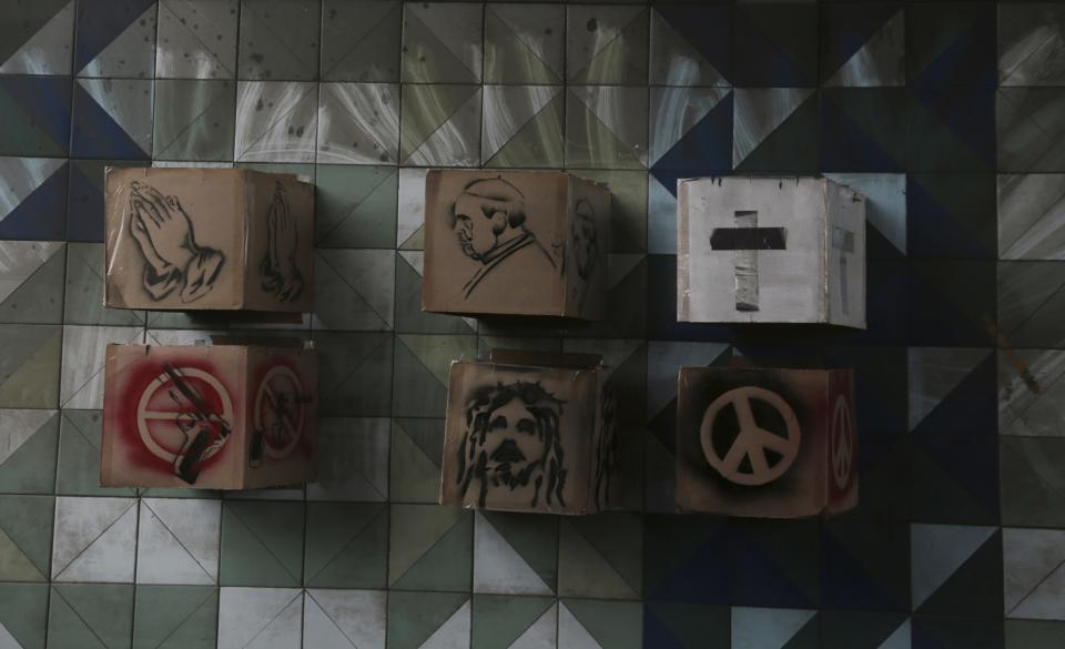 <p>Boxes featuring images of praying hands, the pope, a cross, a gun, Jesus and a peace sign are attached to the wall of a highway underpass, placed by opposition protesters during a national sit-in against President Nicolas Maduro, in Caracas, Venezuela, Monday, May 15, 2017. (AP Photo/Fernando Llano) </p>