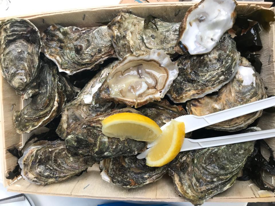 carton of fresh oysters and lemon wedges from a french market