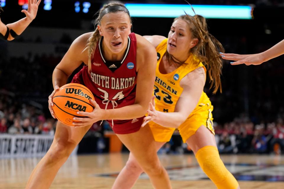 South Dakota's Hannah Sjerven (34) controls the ball as Michigan's Danielle Rauch (23) defends during the first half of a college basketball game in the Sweet 16 round of the NCAA women's tournament Saturday, March 26, 2022, in Wichita, Kan.