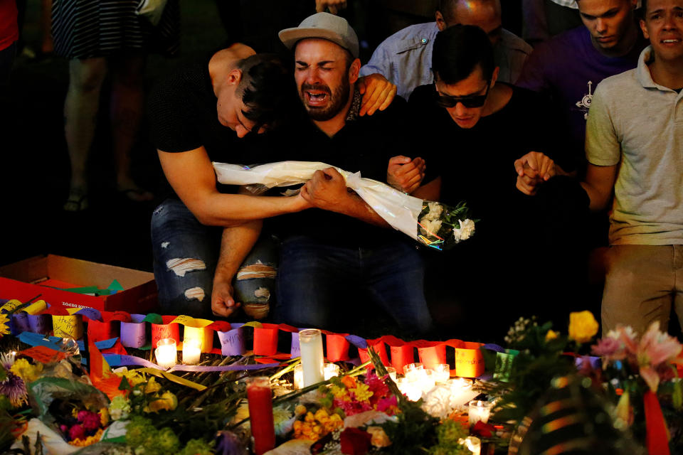 <p>A man cries after taking part in a candlelight memorial service the day after a mass shooting at the Pulse gay nightclub in Orlando on June 13, 2016. (Photo: Carlo Allegri/Reuters) </p>