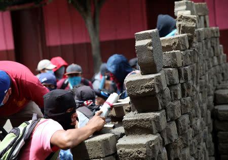 Demonstrators take cover at a barricade during a protest against the government of Nicaraguan President Daniel Ortega in Masaya, Nicaragua June 19, 2018. REUTERS/Andres Martinez Casares