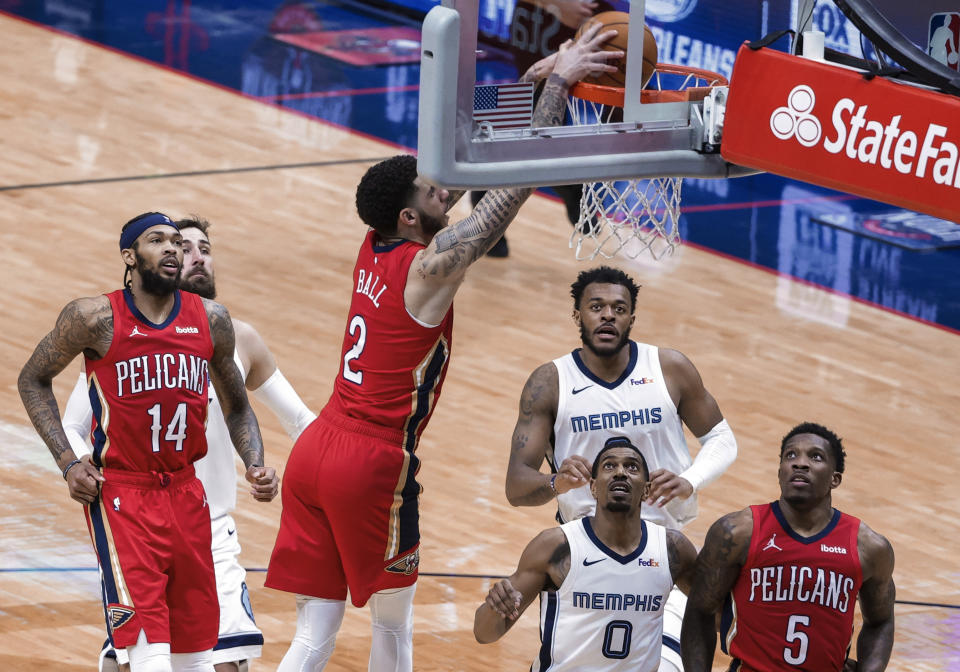 New Orleans Pelicans guard Lonzo Ball (2) dunks over Memphis Grizzlies guard De'Anthony Melton (0) during the second quarter of an NBA basketball game in New Orleans, Saturday, Feb. 6, 2021. (AP Photo/Derick Hingle)