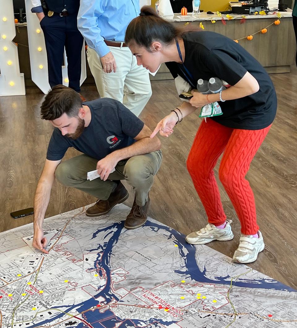 Matthew Tindal of Goodwyn Mills Cawood helps a Gadsden resident locate where she lives and works on a floor map of the city on Sept. 19, 2023, during the GROW Gadsden interactive meeting on the city's upcoming comprehensive master plan at the East Gadsden Community Center.