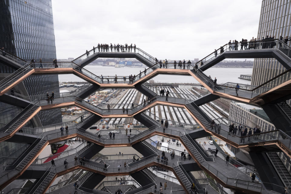 FILE - In this March 15, 2019, file photo, visitors to the Vessel climb its staircases on its opening day at Hudson Yards in New York. The Vessel, a climbable sculpture that drew hordes of tourists to the Hudson Yards mega-development on Manhattan’s west side before a string of suicides forced its closure in 2021, will reopen to the public later this year with added safety measures. (AP Photo/Mark Lennihan, File)