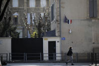 A woman walks past a Jewish school after a man visibly brandished a knife outside a Jewish school and a kosher market in Marseille, southern France, Friday, March 5, 2021. Police detained a man Friday who was wielding a knife outside a Jewish school and kosher market, and increased surveillance of Jewish sites in the city while they investigate his motives, according to local authorities. (AP Photo/Daniel Cole)