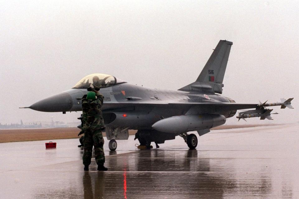 Weapons crew for the Portuguese Air Force Detachment deployed to Aviano Air Base, Italy, in support of NATO Operation "ALLIED FORCE" , gives the pilot the " all stop signal as he prepares the aircraft for de-arming. March 26, 1999 following a mission over Yugoslavia.