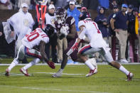 Mississippi State running back Jo'quavious Marks (7) attempts to run past Mississippi defensive backs Keidron Smith (20) and Jake Springer (1) during the first half of an NCAA college football game Thursday, Nov. 25, 2021, in Starkville, Miss. (AP Photo/Rogelio V. Solis)