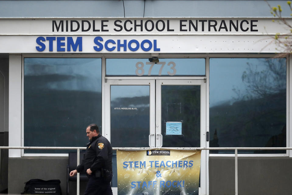 FILE - In this May 8, 2019 file photo, a Douglas County, Colo., Sheriff's deputy walks past the doors of the STEM Highlands Ranch school in Highlands Ranch, Colo. The younger of two students charged in a school shooting in suburban Denver that killed a classmate has pleaded guilty. Prosecutors say 16-year-old Alec McKinney pleaded guilty on Friday, Feb. 7, 2020 to 17 felonies, including a first-degree murder charge. In December, a judge ruled that McKinney would be prosecuted as an adult in the May 7 shooting at STEM School Highlands Ranch that killed 18-year-old Kendrick Castillo. Devon Erickson has pleaded not guilty to the same charges McKinney faced in the shooting.(AP Photo/David Zalubowski, File)