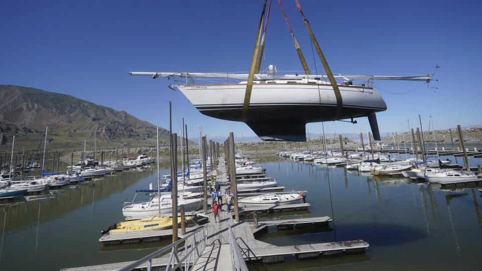 Sailboats are hoisted out of the water at the Great Salt Lake Marina on June 3, 2021, near Salt Lake City. The boats were removed this year to keep them from getting stuck in the mud. (AP Photo/Rick Bowmer)