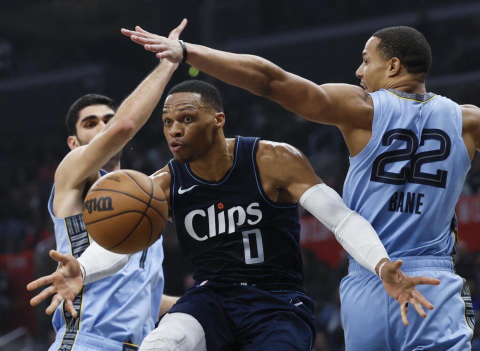 Clippers guard Russell Westbrook, center, slips past Memphis Grizzlies guard Desmond Bane.