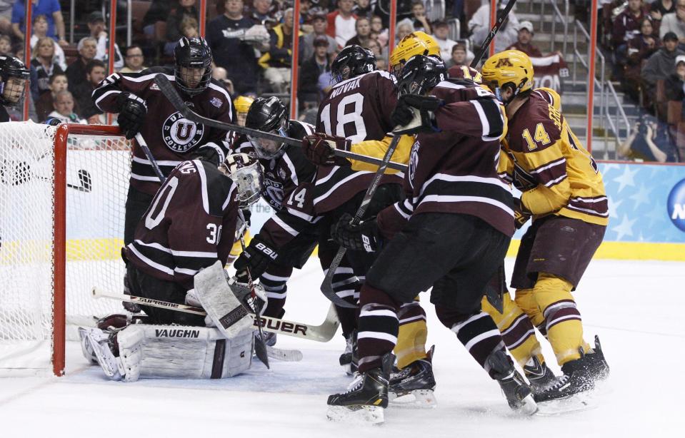 Union goaltender Colin Stevens (30) keeps control of the puck with teammates holding off Minnesota players during the second period of an NCAA men's college hockey Frozen Four tournament game on Saturday, April 12, 2014, in Philadelphia. (AP Photo/Chris Szagola)