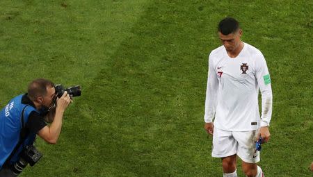 Soccer Football - World Cup - Round of 16 - Uruguay vs Portugal - Fisht Stadium, Sochi, Russia - June 30, 2018 A photographer captures Portugal's Cristiano Ronaldo as he looks dejected while he walks off the pitch after the match. REUTERS/Sergio Perez