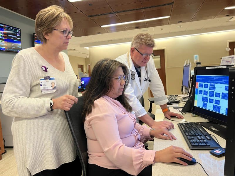 Left to right, registered nurse Carrie Sinisko, the Emergency Department outcomes manager, Grace Delizo-Grabe, the clinical quality leader, and Dr. Steven Coker Jr., the Emergency Department medical director, review a sepsis process review chart in the Northwestern Medicine Delnor Hospital Emergency Department. Photo courtesy of Northwestern Medicine