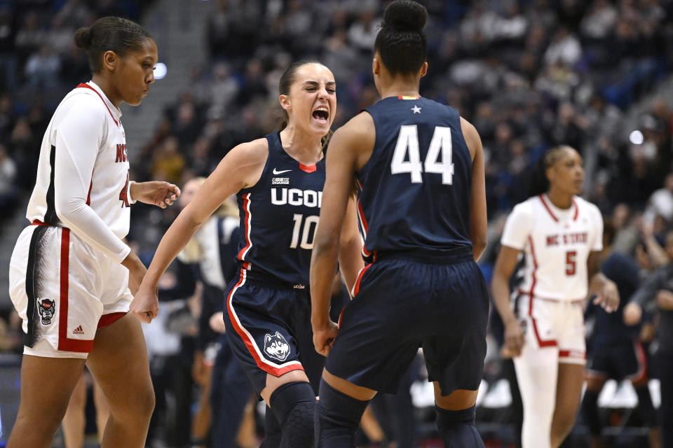 Connecticut's Nika Muhl (10) celebrates with Aubrey Griffin (44) during the first half of an NCAA basketball game against North Carolina State, Sunday, Nov. 20, 2022, in Hartford, Conn. (AP Photo/Jessica Hill)