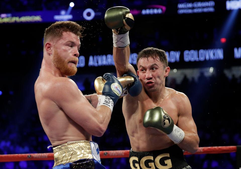 Gennady Golovkin, right, throws a right at Canelo Alvarez during a middleweight boxing bout Saturday, Sept. 16, 2017, in Las Vegas. (AP Photo/John Locher)